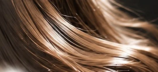 光を受けて艶めく、なめらかな茶色のロングヘアのクローズアップ